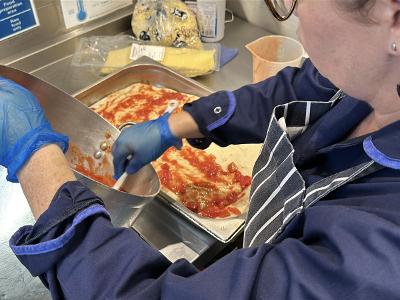 School meals A member of catering staff preparing a fresh meal in a school kitchen