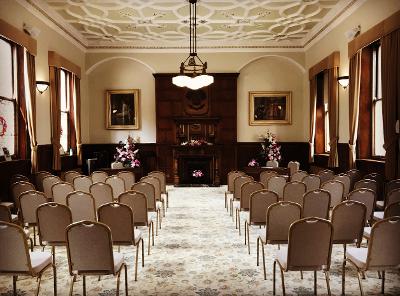 Ceremony Room - June 2022 Ceremony Room at St Helens Town Hall, featuring rows of seats, dark wood panelling, paintings, low-hanging light fitting and dual aspect windows