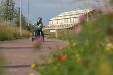 Wheelchair user on a path in a park