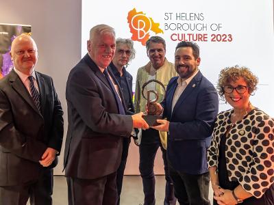 Leader of St Helens Borough Council David Baines receives the LCR Borough of Culture sculpture from Knowsley Council Leader Councillor Graham Morgan with Kath O'Dwyer; Chief Executive at St Helens Borough Council, watching on alongside LCR Mayor Steve Rot