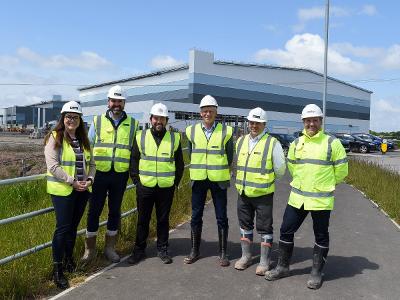 Councillor Kate Groucutt, Council Leader Councillor David Baines and officials from the developers at Omega West outside one of the new units being built