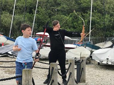 Children and young people participating in problem solving games and an archery session